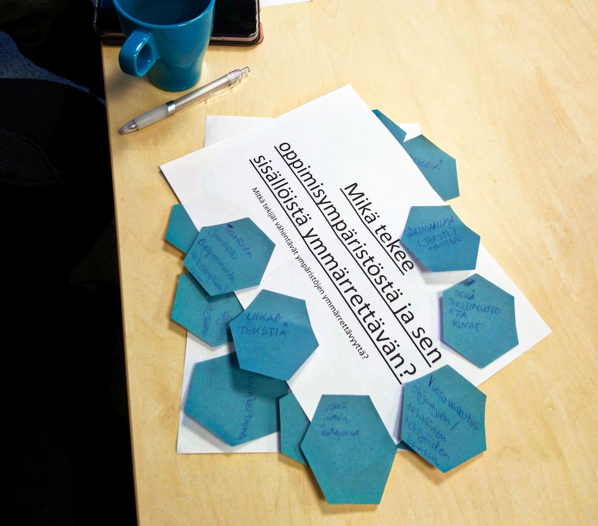 Pöydällä on yhteisen työskentelyn jäljiltä muistilappuja.