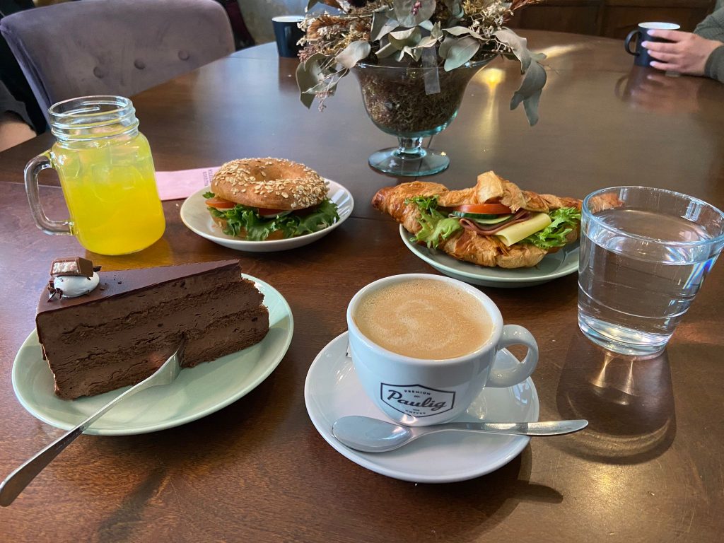 Kehittäjätiimi pöydän ympärillä kahvilaherkkujen äärellä. Kuvasta kiitos kehittäjätiimin osallistujalle Roopelle.